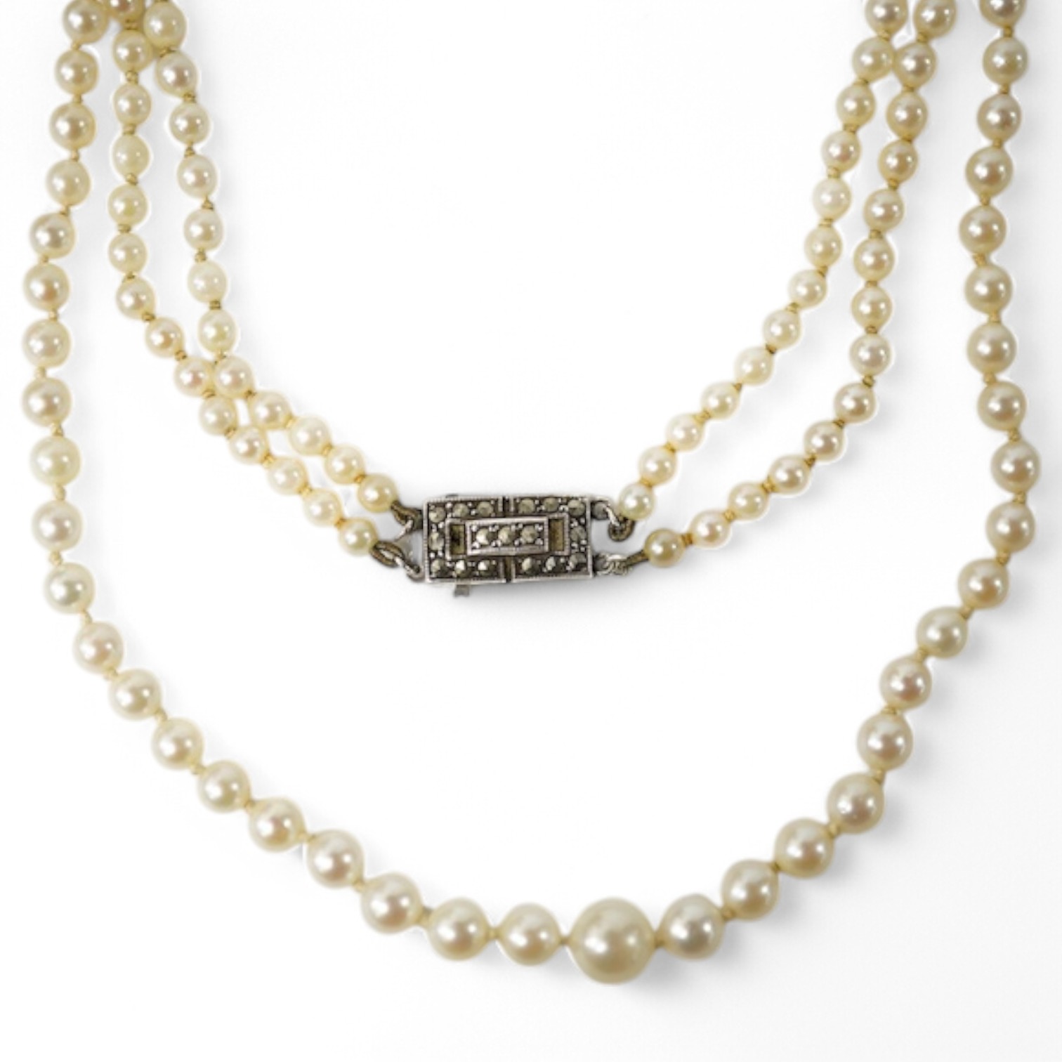 A double strand graduated culture pearl necklace, with marcasite set sterling clasp, 46cm and one other single strand cultured pearl necklace. Condition - fair